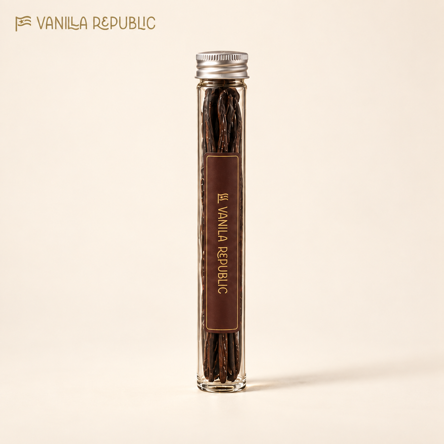 Vanilla Republic whole beans in a slender glass tube with silver cap on a warm cream background